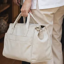 Enfermera a domicilio sujetando su bolsa de lona en la puerta de una vivienda