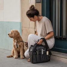 Peluquera canina en un portal con su equipo y un perro tranquilo al lado